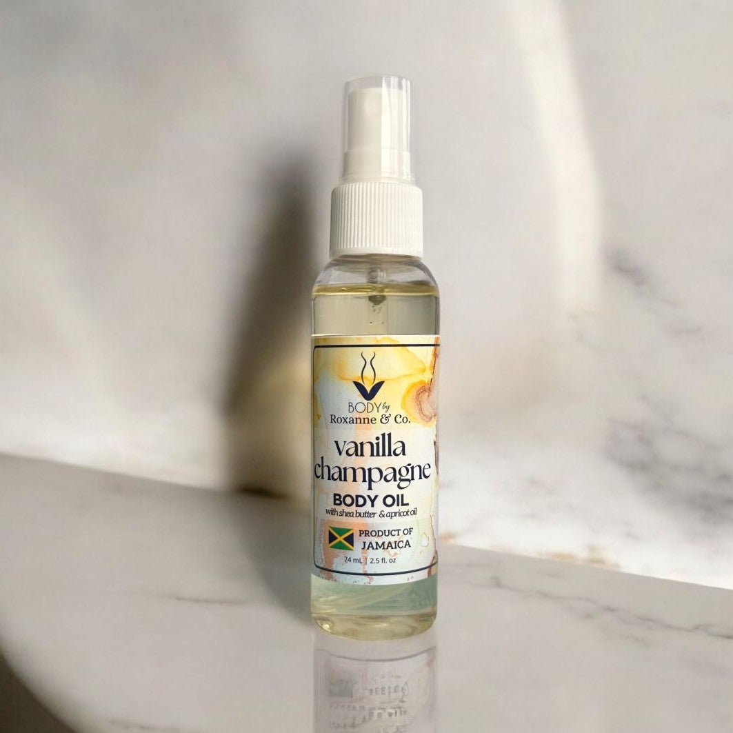 Bottle of Vanilla Champagne body oil on a marble surface with a neutral background