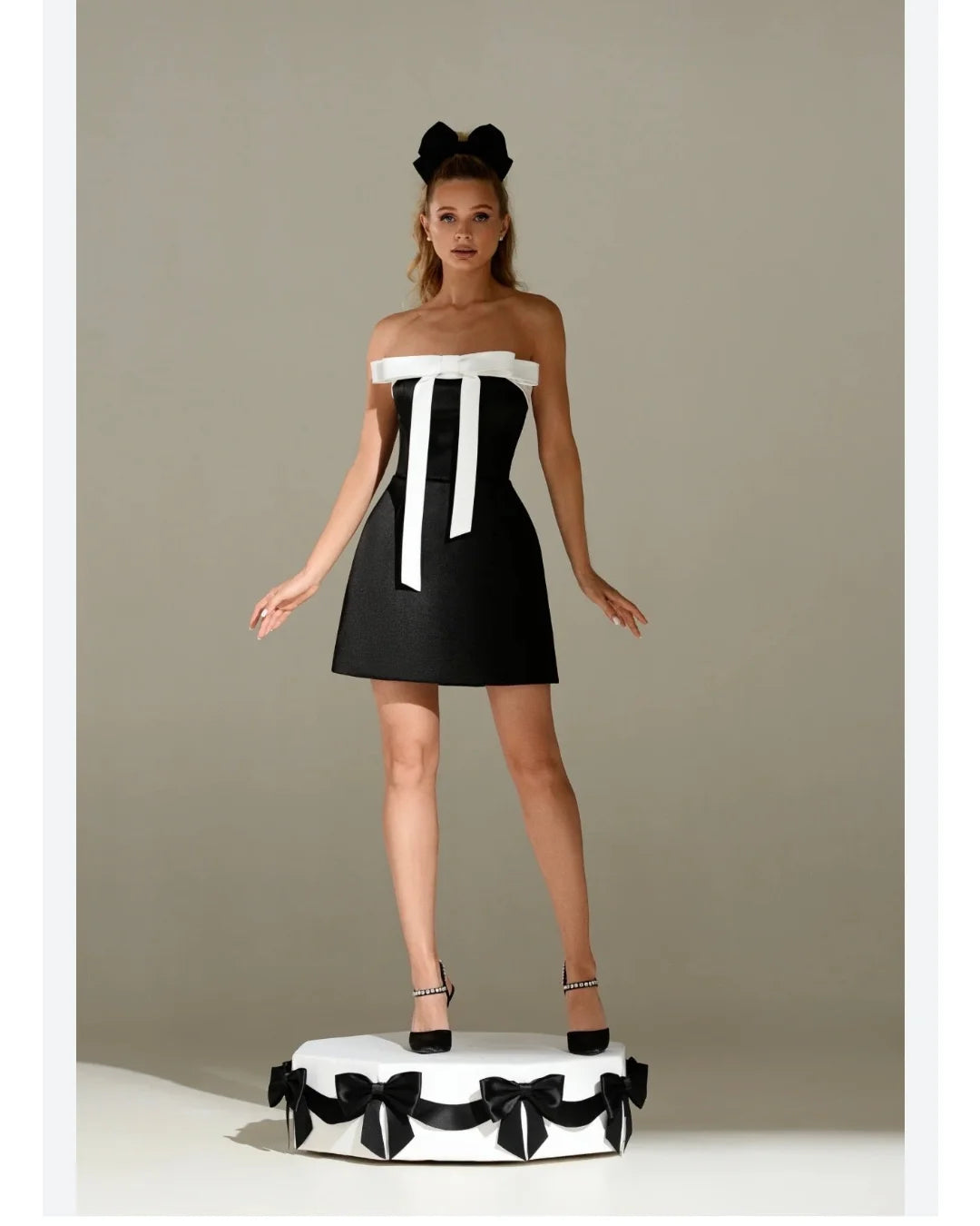 Amstoosh black strapless tube mini dress with front bow detailing — on model