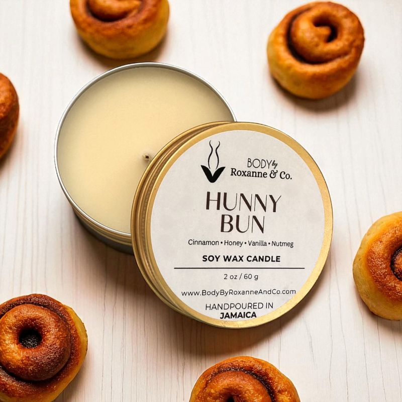 Hunny Bun soy wax candle by Body by Roxanne & Co. with cinnamon rolls in the background.