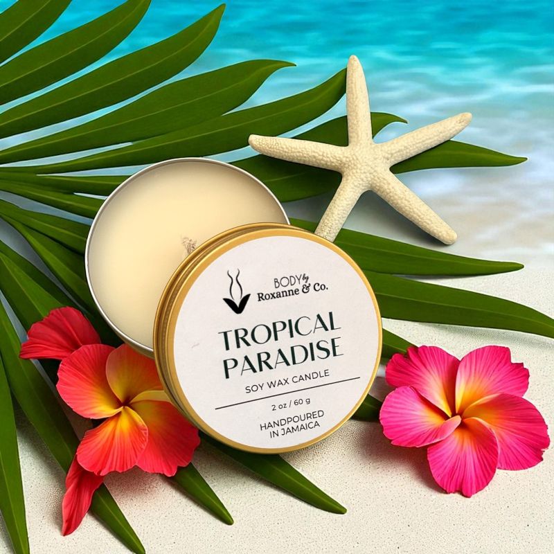 Tropical Paradise candle with starfish, flowers, and palm leaves on a beach background